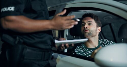 Man, police and stop car for fine of speeding ticket, registration check and traffic warning. Person, law enforcement and licence for drunk driving, legal penalty and transport risk of crime at night