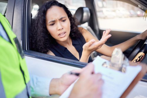young woman annoyed she is getting a traffic ticket - contest traffic ticket concept