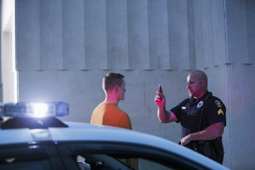 Police officer giving sobriety test to young man - challenging field sobriety tests concept