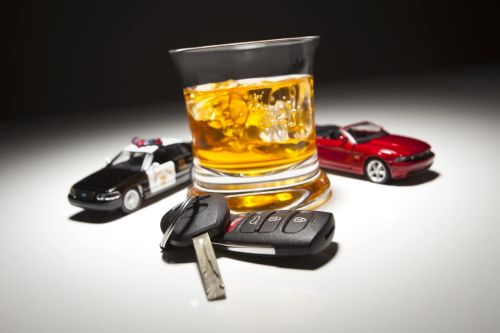 Highway Patrol Police and Sports Car Next to Alcoholic Drink and Keys Under Spot Light. Multiple DWI Concept