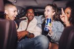 group of friends in back seat of a car drinking and having fun - open container law for motor vehicles concept