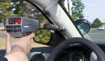A police officer is using a handheld RADAR gun to target a vehicle coming off a bridge - north carolina speeding ticket concpet